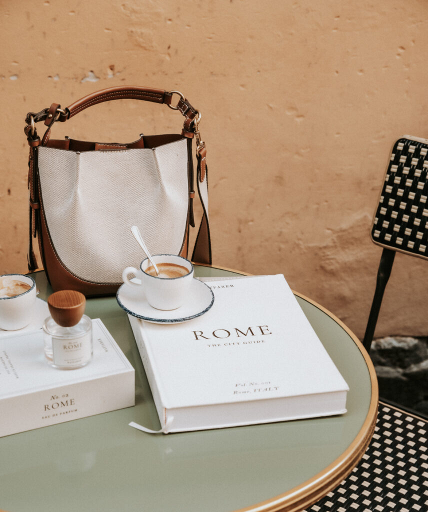 cafe setting in rome with purse and wayfarer travel guide on the table